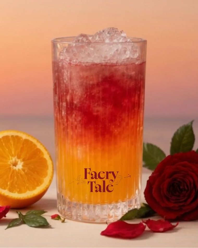 Drink Twilight em degradê de laranja e bordô ao lado da garrafa de Faery Tale